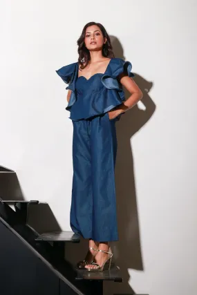 Denim jumpsuit with thick white stitching, bustier and frill feature around the neckline and shoulders.